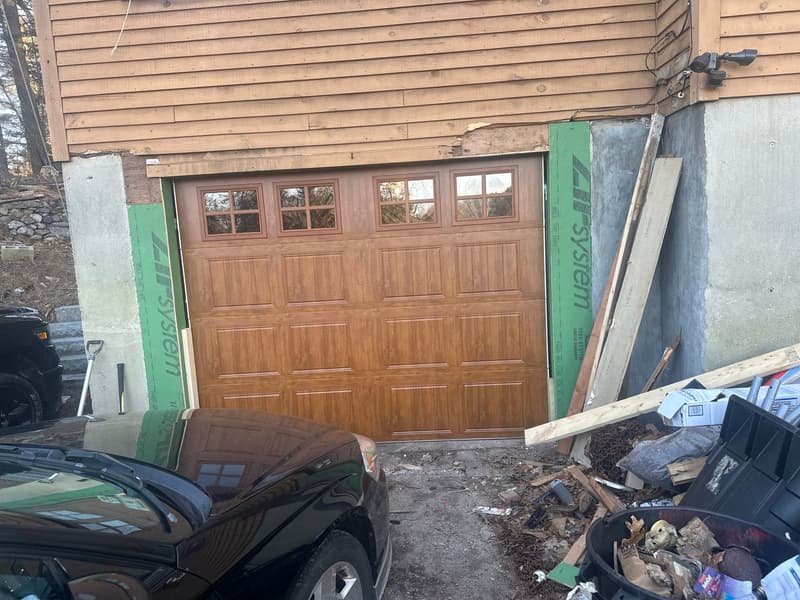 Wood-tone raised-panel garage door with windows installed during new construction